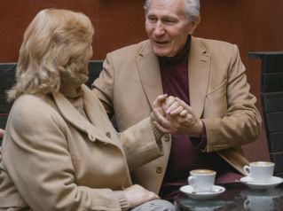 Sweet moment of a senior couple sharing coffee and romance outdoors.